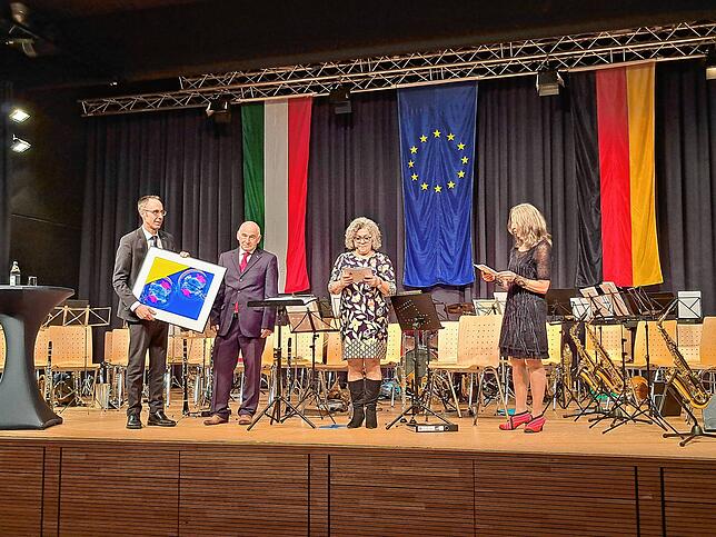 Geschenkübergabe auf der Bühne: Bürgermeister Harsch überreichte seinem italienischen Amtskollegen Claudio Magro ein Abzug der ...