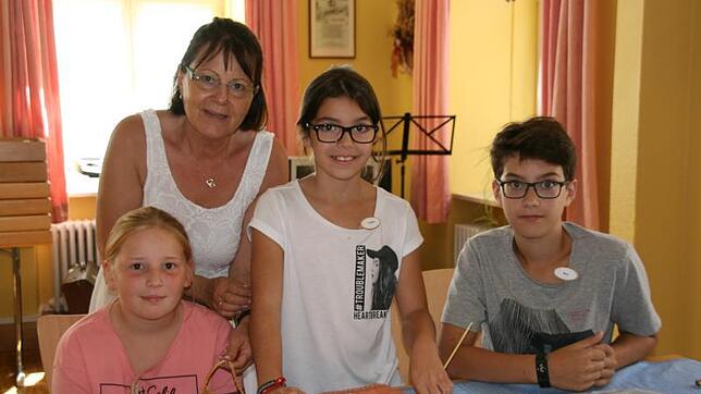 Viel Spaß haben beim Strohflechtkurs im Rahmen des Ferienprogramms die Kindern Marlene (von links), Luana und Rico mit Anleiterin ...