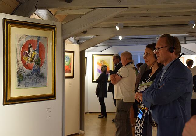 Besucher nutzten bei der Vernissage am Freitag den neuen Audioguide mit Kopfhörern. Links ist hier die Lithografie &bdquo;Das Liebespaar ...