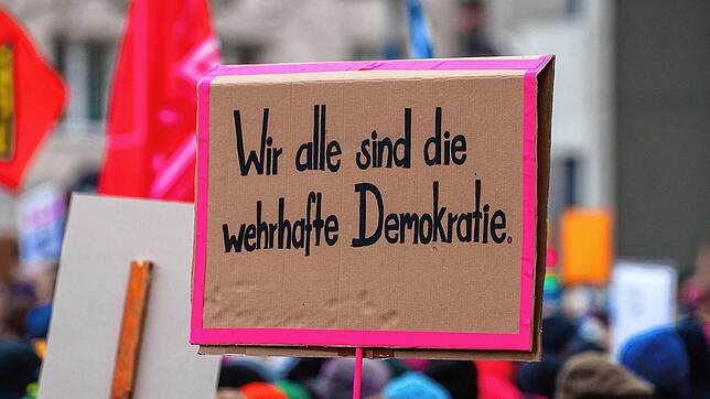 Ein Plakat ·Wir alle sind die wehrhafte Demokratie· wird auf einer Kundgebung gegen Rechtsextremismus gezeigt. In ganz Deutschland gehen ...