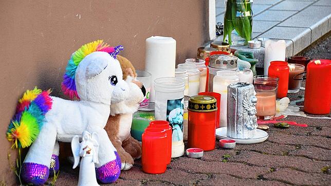Plüschtiere und Kerzen stehen am Hauseingang zum Tatort in Hockenheim. Dort sind am Ostersonntag zwei Geschwister tot in einer Wohnung ...