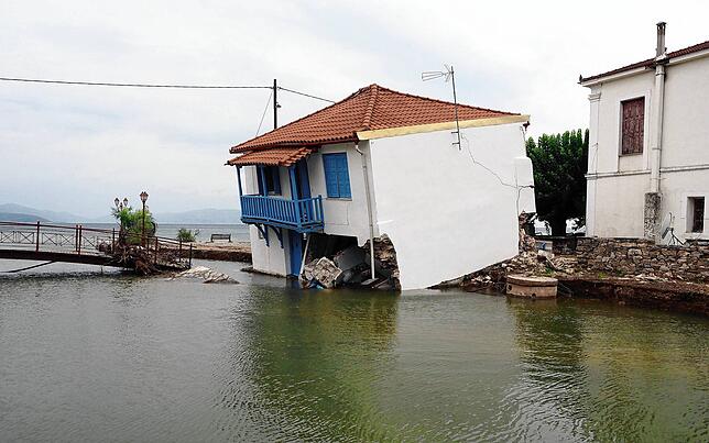 Ein Haus steht in Horto in Griechenland nach starken Regenfällen schräg im Hochwasser.