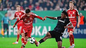 Johan Manzambi (l, SC Freiburg) blockt den Torschuss von Anouar El Azzouzi (Fortuna Düsseldorf).