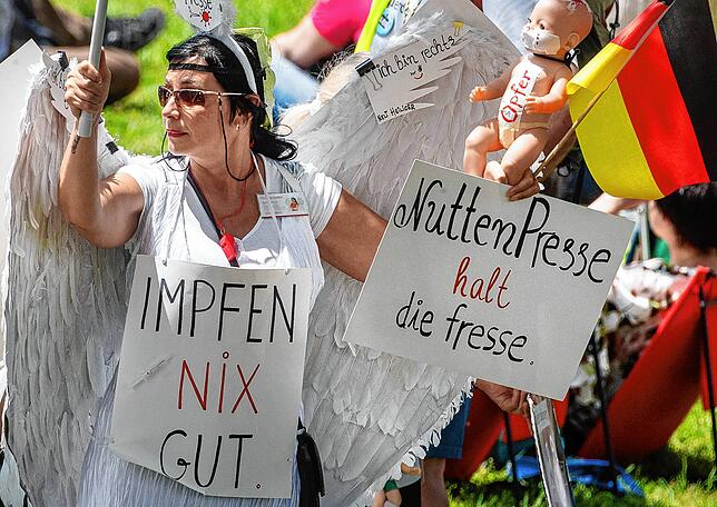 &bdquo;Impfen Nix Gut&ldquo; und &bdquo;Nutten Presse halt die fresse&ldquo; steht auf dem Schild einer Demonstrantin, die an einer ...