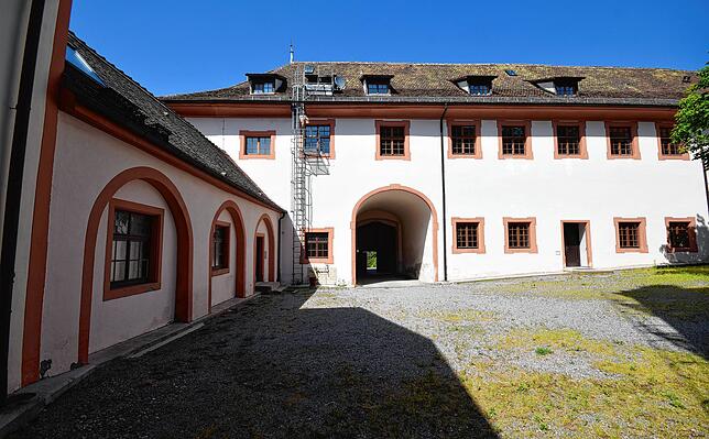 Das Tor im Durchgang in der Bildmitte ist der Eingang zum Schlossinnenhof von außen. Die kleine Tür links führt in die Turnhalle, in der ...