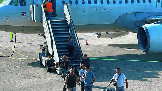 Passagiere verlassen ein Flugzeug auf dem Häfler Rollfeld.