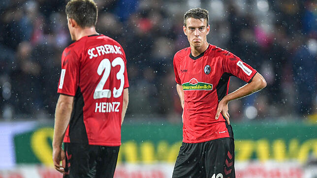 Dominique Heintz und Janik Haberer (r) von Freiburg stehen nach der 1:3-Niederlage enttäuscht auf dem Rasen.
