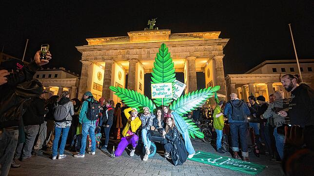 Menschen stehen während eines &ldquo;Smoke In&bdquo; vor dem Brandenburger Tor vor einem großen Hanfblatt. Ab dem 1. April ist ...