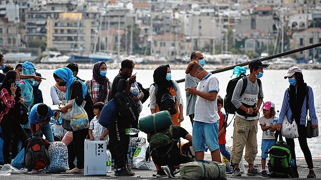 Migranten stehen Schlange, um eine Fähre von der Insel Lesbos zum griechischen Festland zu besteigen.