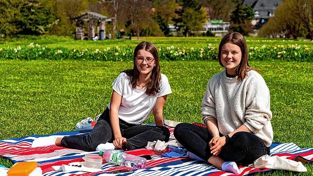Jule Ückert (links) und Elena Gajski genießen den herrlichen Frühlingstag bei einem kleinen Picknick auf der Wiese zwischen den ...