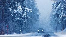 Ein Auto fährt über eine verschneite Straße auf dem Schauinsland.