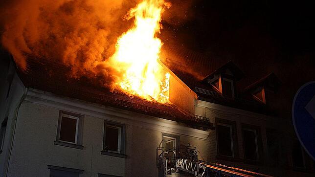 Während die Feuerwehr mit 14 Einsatzkräften im Gebäude nach Menschen sucht, schlagen knapp über der Drehleiter meterhohe Flammen aus dem ...