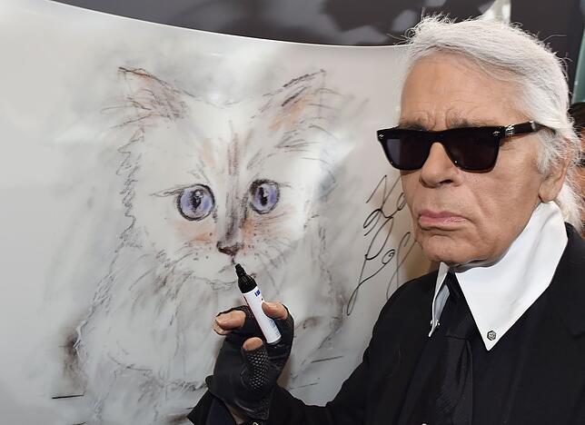 Karl Lagerfeld neben einer Zeichnung mit seiner Katze "Choupette"
