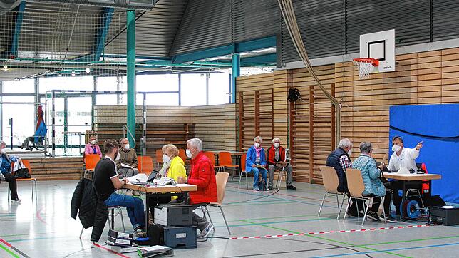 Zwei Mitarbeiter des Impfzentrums Freiburg führen an Tischen Anamnesegespräche, im Vordergrund mit Werner Gaiser, stellvertretender ...