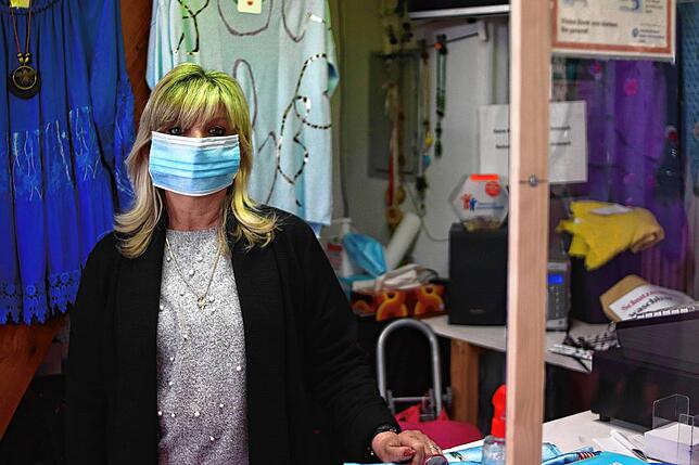 Maria Sostaric mit Maske hinter dem Spuckschutz von &bdquo;Anna Mode&ldquo;. Ihre Maske ist ihr noch ein bisschen zu groß, sie will sich ...