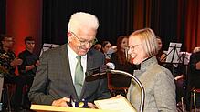Landrätin Stefanie Bürkle überreicht Ministerpräsident Winfried Kretschmann die Bürgermedaille des Landkreises in Gold samt Urkunde.
