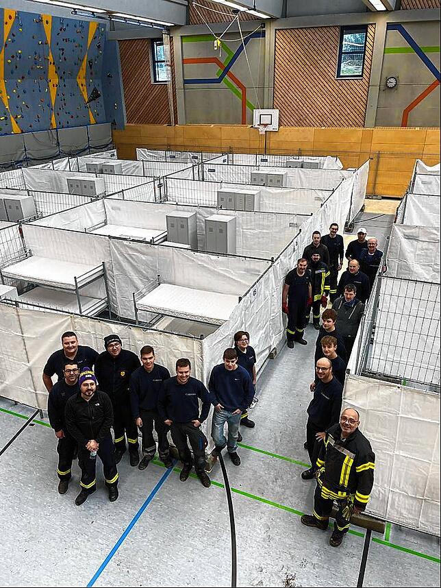 Es ist geschafft. Die Helfer, die in die Kreissporthalle eine provisorische Flüchtlingsunterkunft gebaut haben, stellen sich zum ...