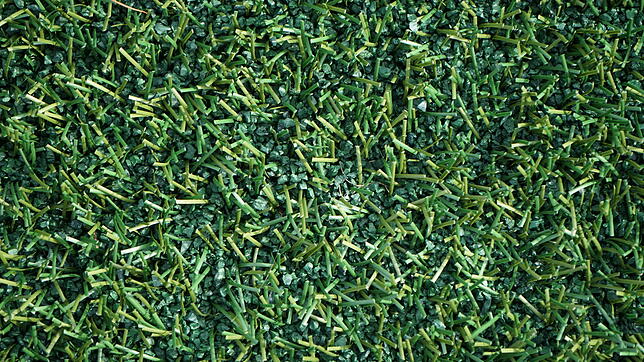 Das Kunststoffgranulat befindet sich zwischen den Plastikhalmen und dämpft die Schritte der Sportler ab.