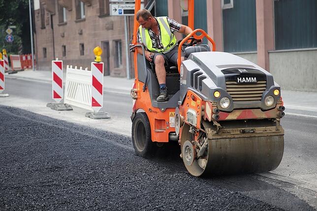 Der Feinschliff: Die oberste Asphaltschicht ist hart wie glas und soll möglichst eben sein. Dafür kommt eine Walze zum Einsatz, die ...