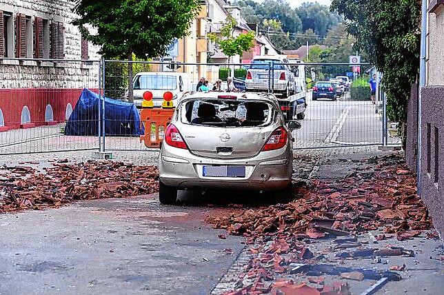 Die Fahrzeuge, die in der Brandnacht vor dem Haus parkten, sind schwer beschädigt. Der Bereich ums Brandhaus ist mit Bauzäunen abgesperrt.