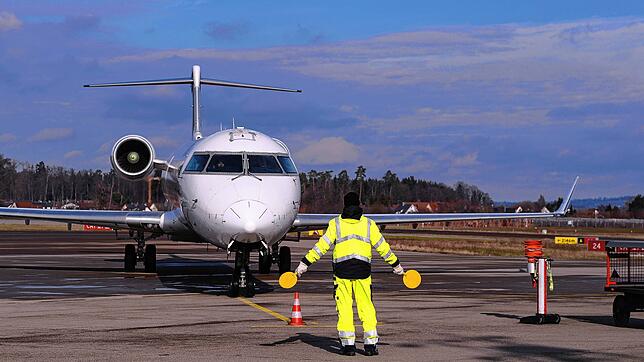 Ein Flugzeug wird am Bodensee-Airport Friedrichshafen eingewiesen.