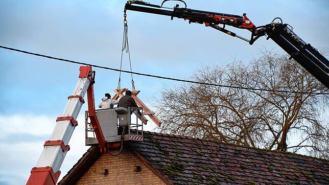 Der Dachreiter für das neue Storchennest kommt per Kran-Arm auf das Dach der Scheune auf dem Brauerei-Areal.