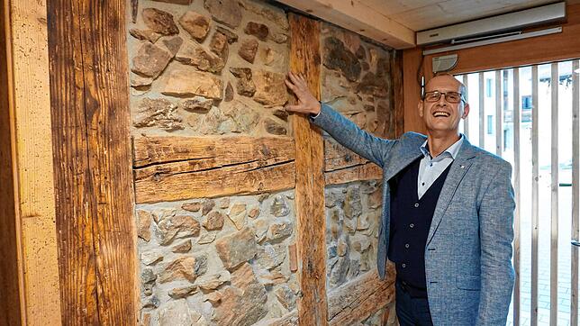 Einen Teil der historischen Bruchsteinmauern des alten Gebäudes zeigt Ortsvorsteher Klaus Müller.
