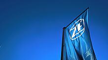 Eine Fahne mit dem Logo der ZF Friedrichshafen weht vor dem Forum der ZF Friedrichshafen.