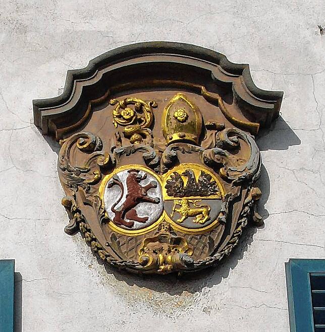 Den Südflügel ziert das Wappen des Hofes: In ihm sind das Stifterwappen der Herren von Schussenried (roter Löwe) und das Wappen des ...