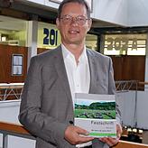 Manfred Römersperger mit der Festschrift anlässlich des 50. Geburtstags des Klettgau-Gymnasiums, er ist der vierte Schulleiter der Schule.