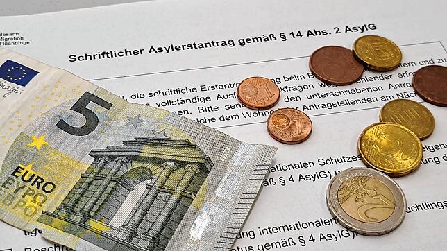 Ein Geldschein und Münzen liegen auf einem Asylantragsformular. In Zukunft sollen Geflüchtete im Schwarzwald-Baar-Kreis nur noch wenig ...