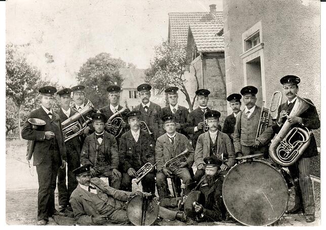 Der Verein während der Jahrhundertwende im Kaiserreich um 1900 mit 16 Musikern in der Dorfmitte.