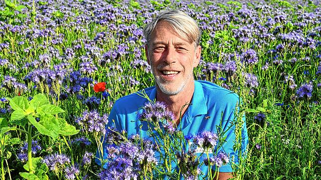 Nebenerwerbslandwirt Andreas Danner in einem Meer von Phacelia. Mit den Blühpflanzen unterstützt er die Artenvielfalt in der Region.