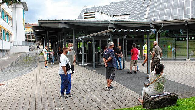 Rund ein Dutzend Impfwillige warten am Montagnachmittag vor der Jahnhalle, um sich registrieren zu lassen. Sie werden etappenweise ...