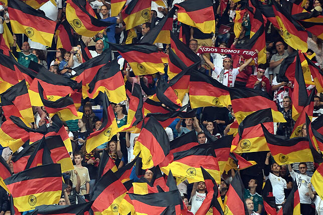 Eine einzelner Fan von Peru hält einen Schal mit der Aufschrift "Todo somos Peru" (Wir sind alle Peru) inmitten von deutschen Fans die ...
