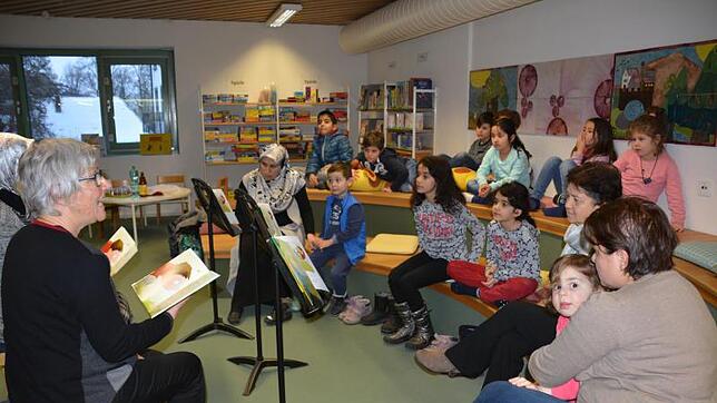 Aufmerksam lauschen die Kinder den von Christiane Lange (vorn links) und Hanife Yazici in deutsch und türkisch vorgelesenen ...