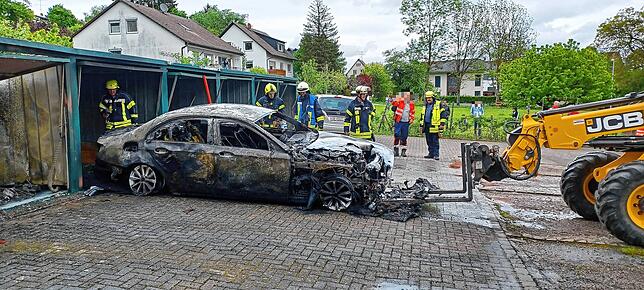 Ein Radlader zieht das völlig ausgebrannte Auto aus der Garage.