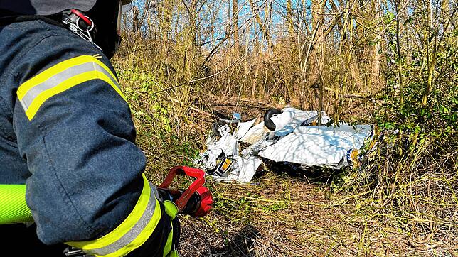 Feuerwehrleute erreichen das Wrack der abgestürzten zweisitzigen Maschine vom Typ „Grumman“ am Sonntagnachmittag, 27. März. ...