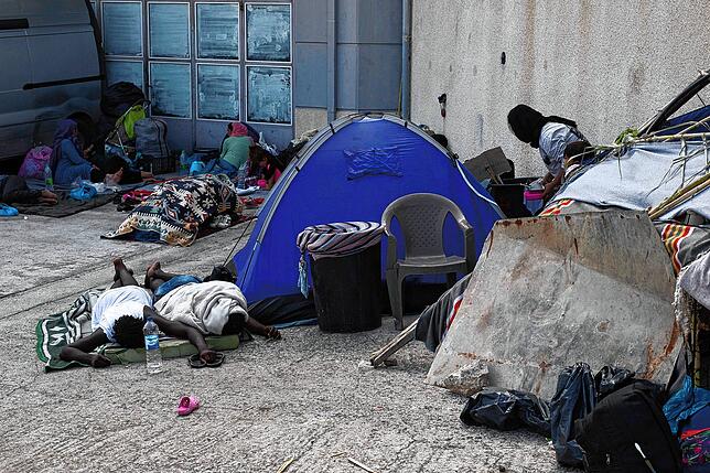 Migranten schlafen neben einem Zelt in der Nähe der Stadt Mytilene an der nordöstlichen Seite der Insel Lesbos. Der griechische ...