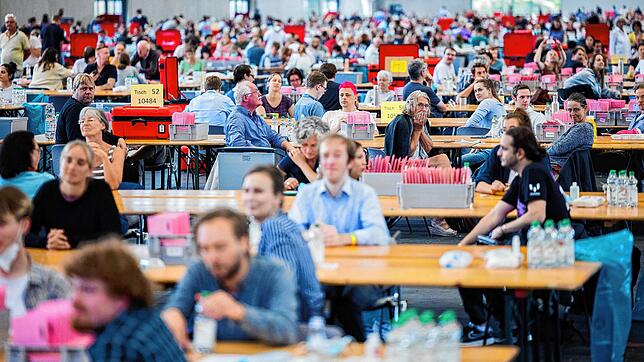 Wahlhelferinnen und Wahlhelfer warten in Köln auf den Beginn der Auszählung der Briefwahl zur Bundestagswahl in der Messehalle 6. Der ...