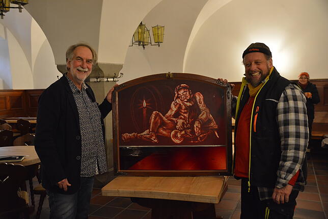 Bernd Engesser vom Bauamt und Glasveredler Andreas Dierig (von links) mit der Scheibe aus dem kleinen Ratsstüble, die vergrößert wurde ...