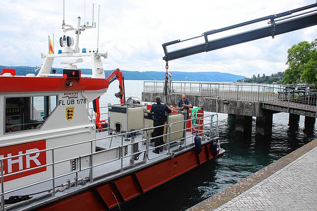 Hier wird der erste Tank mit verschmutztem Wasser auf dem Feuerwehrschiff befestigt. Bild: Reiner Jäckle