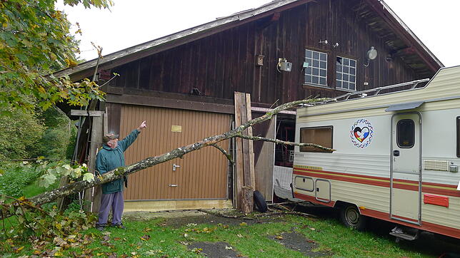 Elmar Walter zeigt die Schäden, die der umgestürzte Baum am Dach des Hauses und am Wohnmobil verursacht hat.