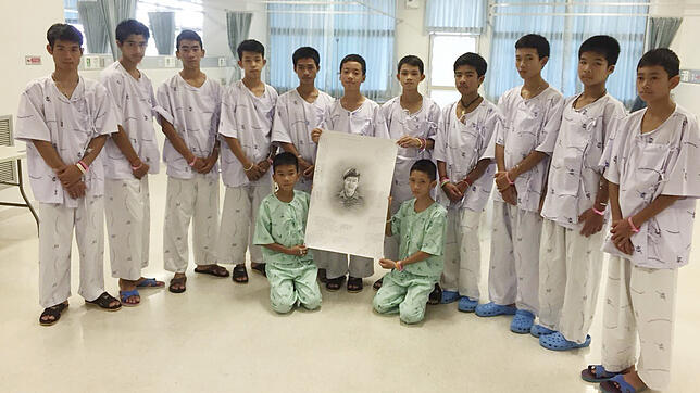 Die geretteten Jungen in der Klinik von Chiang Rai mit einem Bild des Tauchers Saman Kunan von der Thai Navy Seals, der bei ihrer ...