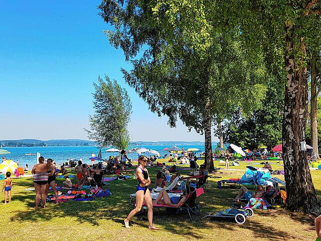 Im Strandbad Iznang bevorzugen Besucher an einem heißen Tag den Schatten der Bäume.