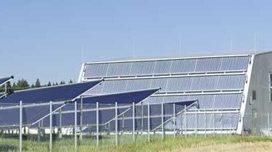 Heizzentrale umgeben von Solarthermiekollektoren. Bild: Solarcomplex