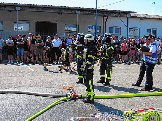 Aktive der Feuerwehren legen Prüfungen für das Leistungsabzeichen in Bronze, Silber und Gold ab. Zuschauer verfolgen das Geschehen.