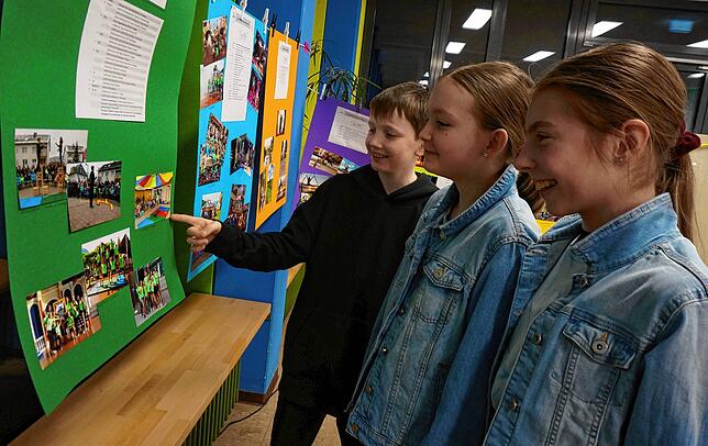 Max, Pia und Samantha schauen sich die Ausstellung &bdquo;15 Jahre Zirkus Zebrasco&ldquo; an (von links).