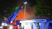 Einsatzkräfte der Feuerwehr löschen einen Brand in Firmen im Gewerbegebiet Freiburg-Hochdorf.
