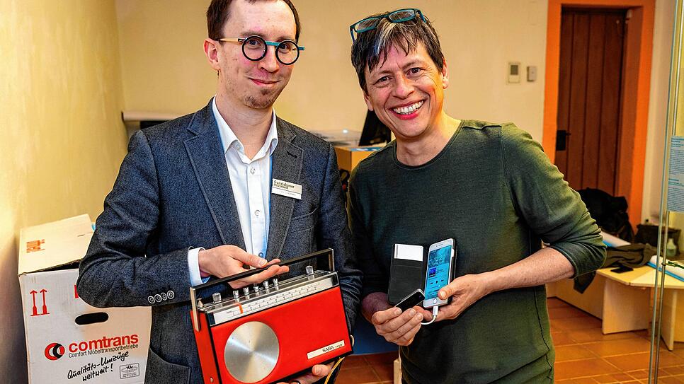 Ausstellungsgestalter Bernhard Abele (rechts) zeigt Kurator Peter Graßmann, dass man das mobile Transistorradio SABA &bdquo;Sandy&ldquo; ...